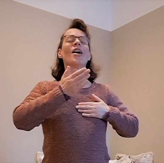 Hyvinvointia ja voimaa omasta äänestä, Satu Haapala, Tmi Resonoiva Ääni: nainen silmät kiinni, suu auki, kädet taputtavat rintaa