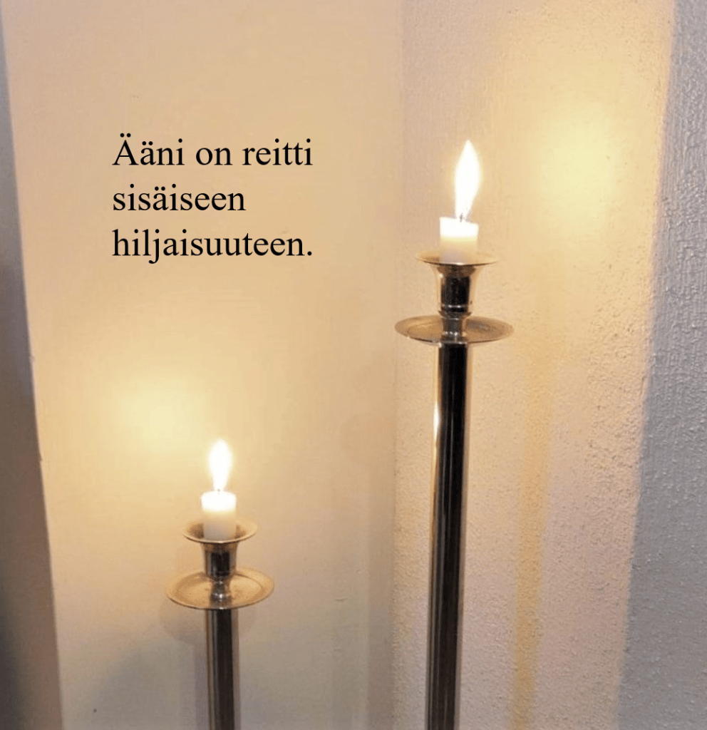 kaksi kynttilää ja teksti "Ääni on reitti sisäiseen hiljaisuuteen"